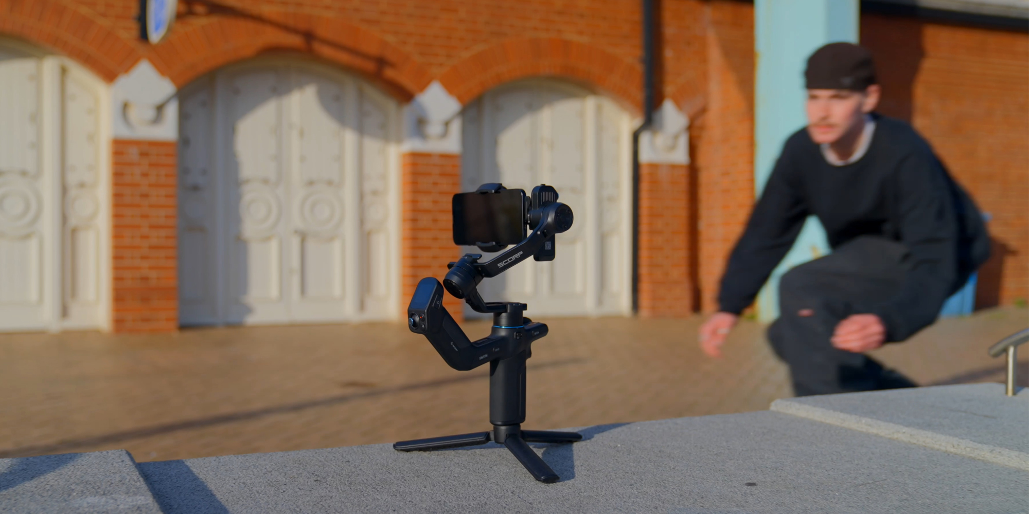 width=100% Gimbal ręczny FeiyuTech Scorp mini 3 Kit podczas nagrywania mężczyzny w ruchu